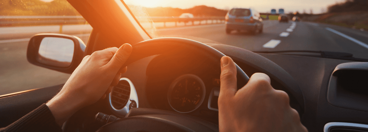 bestuurder heeft handen aan stuur rijdend op snelweg